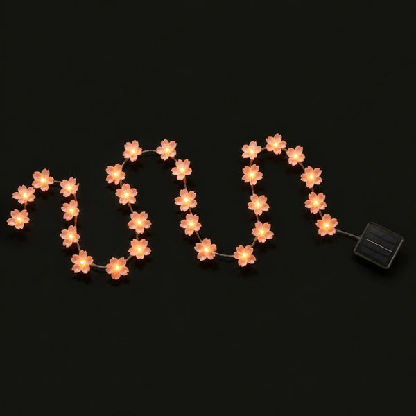 Guirnalda solar de flores de cerezo encendida, con su panel solar